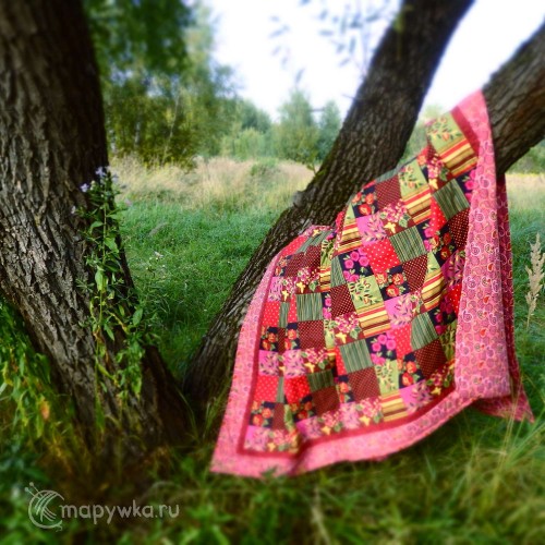 яркое лоскутное одеяло на дереве в деревне